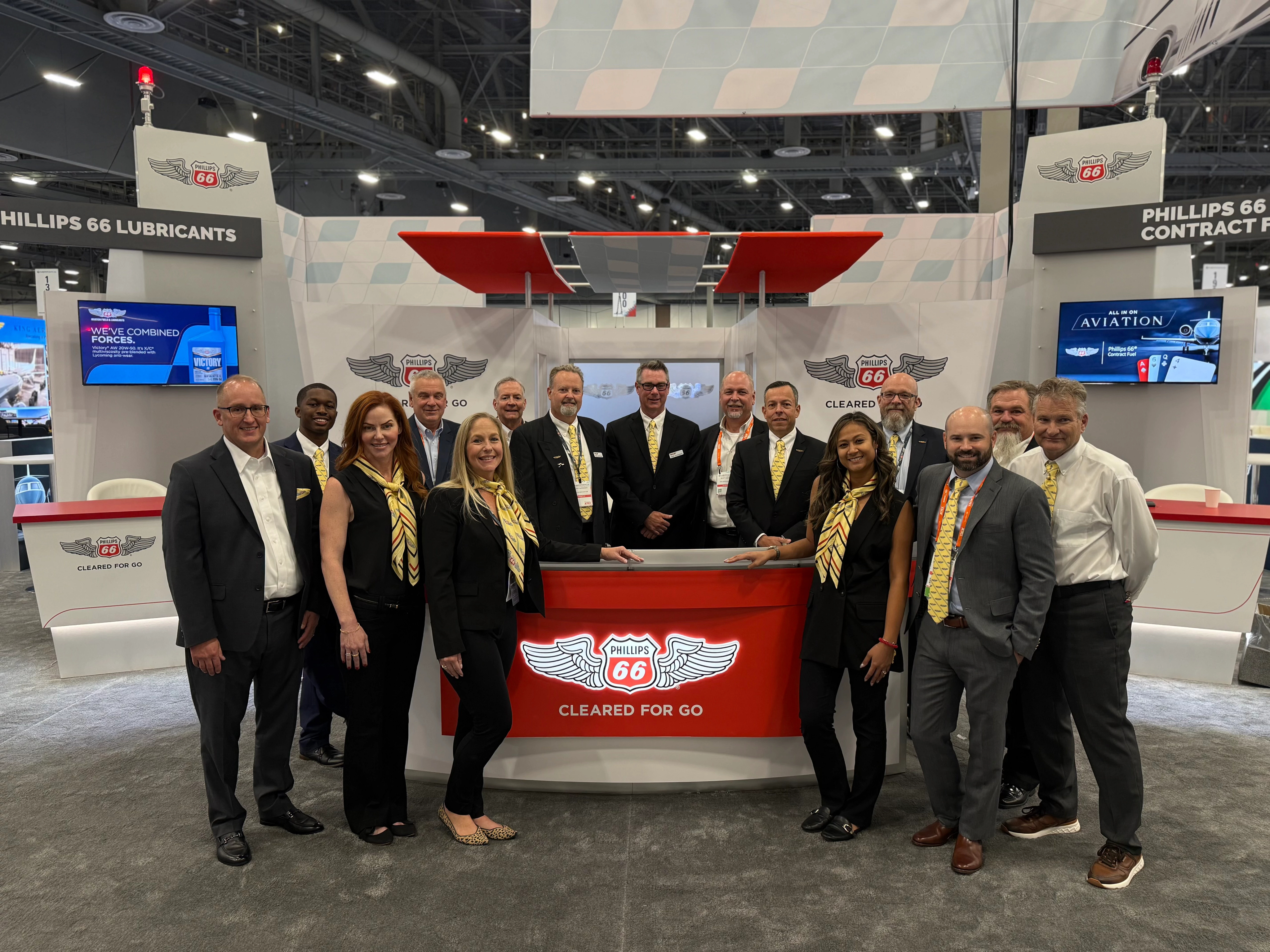 Phillips 66 Aviation team gathered around their conference booth. 